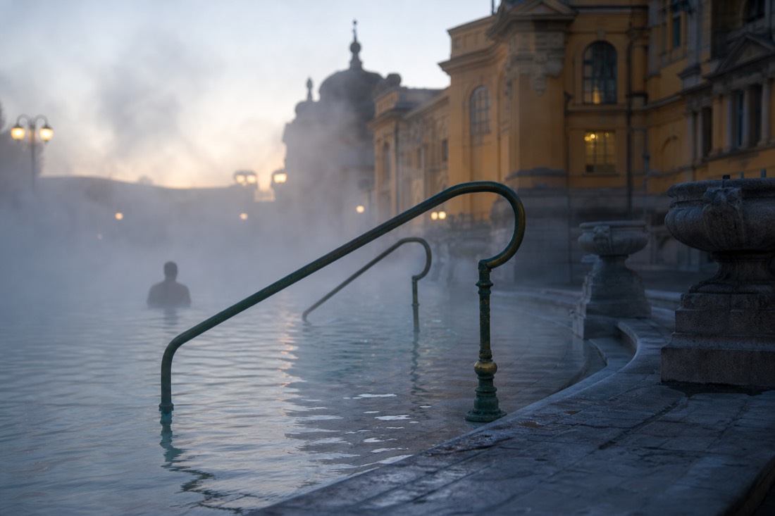 Early morning steam over the outdoor thermal pool at Szechenyi with empty stone steps