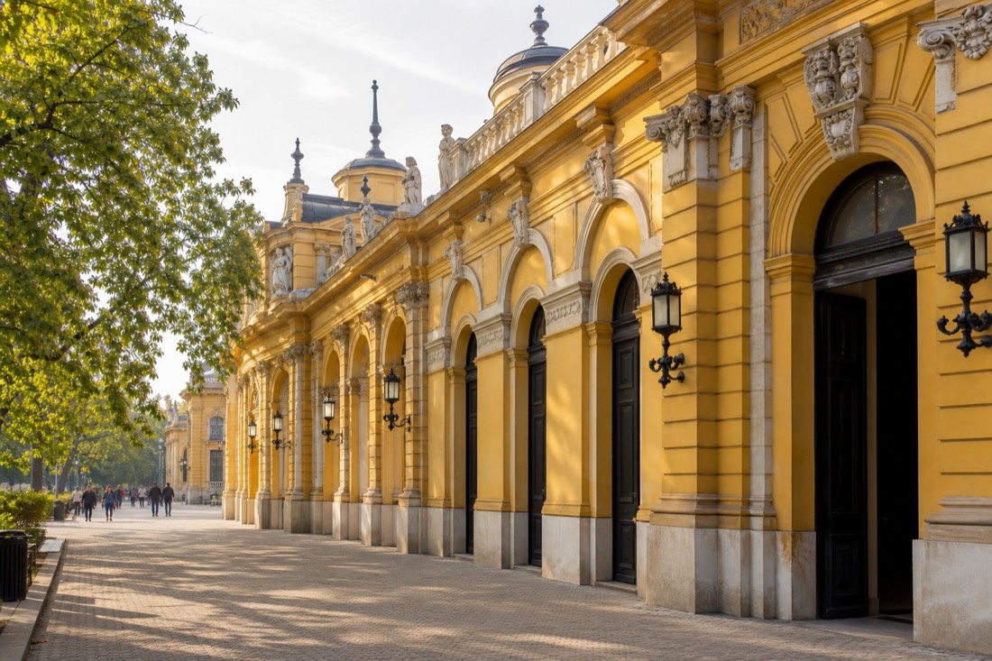 Yellow neo-baroque facade and side doorway at a Budapest bath complex entrance