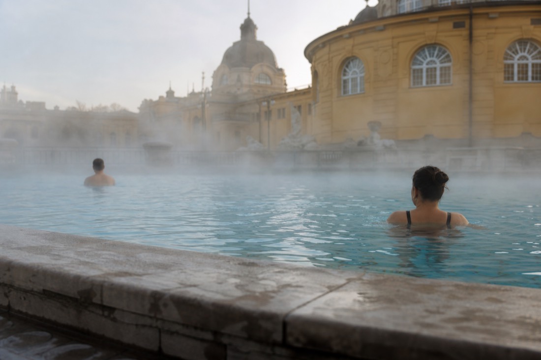 Quiet early morning soak for two in the outdoor thermal pool of a grand Budapest bath