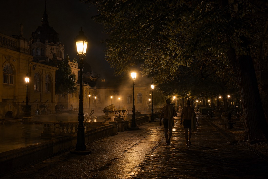 Quiet lamplit park path outside a Budapest bathhouse in the small hours after a night event
