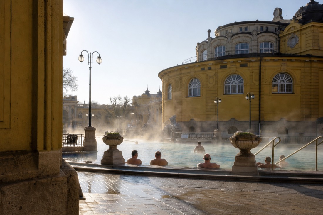 Morning swimmers relaxing in warm thermal water at a Budapest bath courtyard before the crowds arrive