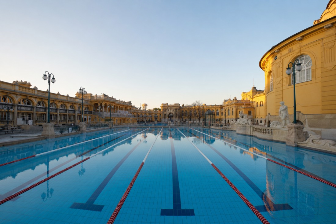 Cool blue 50-metre outdoor swimming pool at a historic Budapest bath with lap lanes and empty morning water